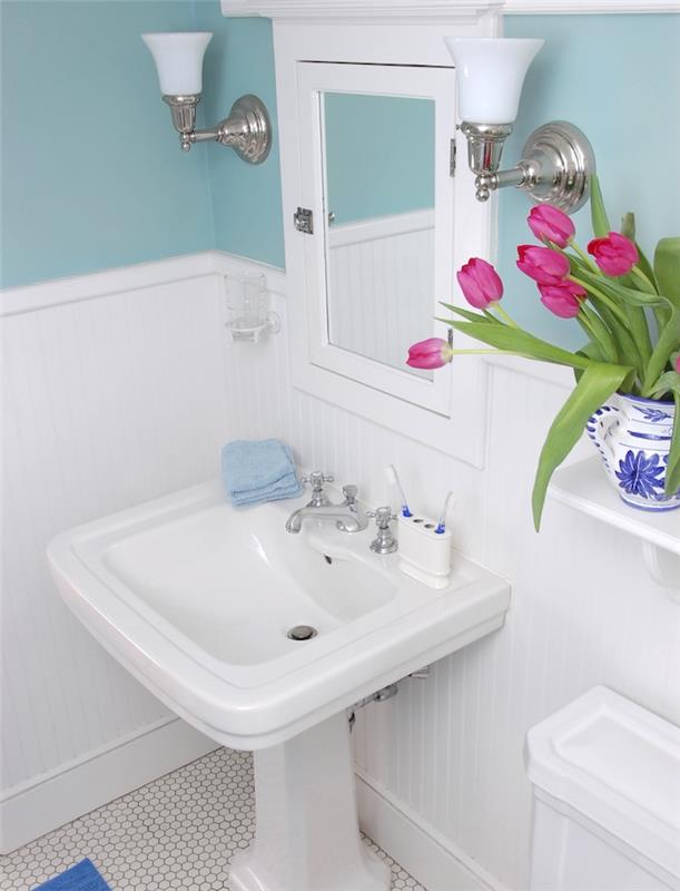 küçük bir tasarımcı banyo örneği, konsol lavabo, ayna, mavi duvar boyası, eski karo zemin, lale buketi