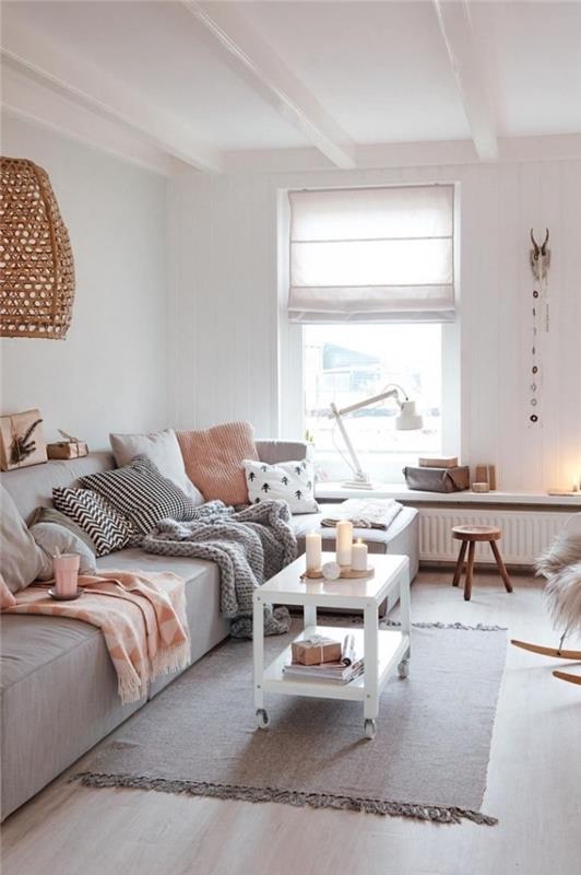 maža svetainė hygge deco minkšta ir šilta, su didele pilka sofa, padengta dekoratyvinėmis pagalvėlėmis