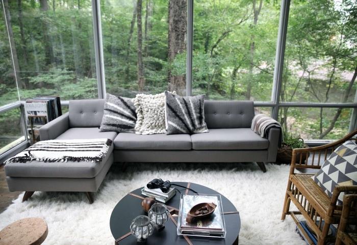 pavyzdys, kaip papuošti šiuolaikišką svetainę su dideliais langais ir mediniu parketu, pilkos spalvos kampinės sofos modelis