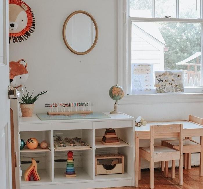 mažas medinis stalas ir kėdės su balta lentyna šalia žaislų, baltos sienos, medinės grindys, lapės rašto deko