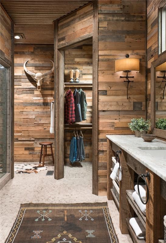 kaimiško stiliaus interjero dizainas mediniame vonios kambaryje, vonios spintelė su atvira saugykla žalia mediena, medinių sienų idėja