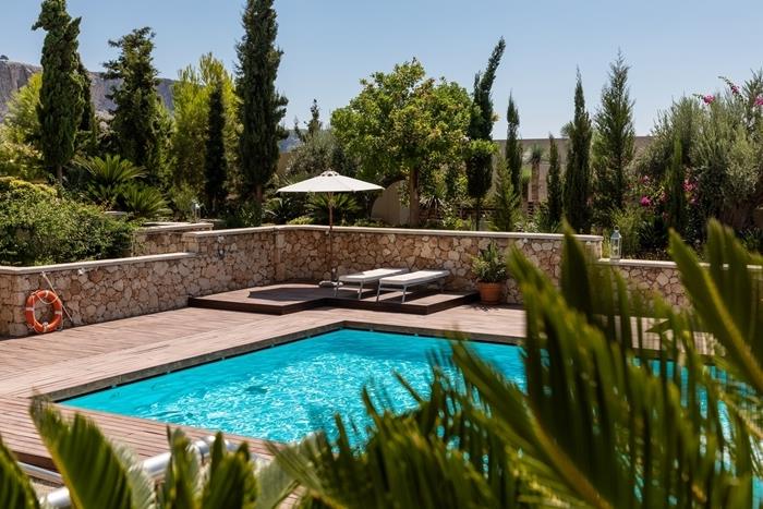 peyzaj yüzme havuzlu bahçe ahşap teras bahçe mobilyaları şezlong güneşlenme palmiye ağaçları