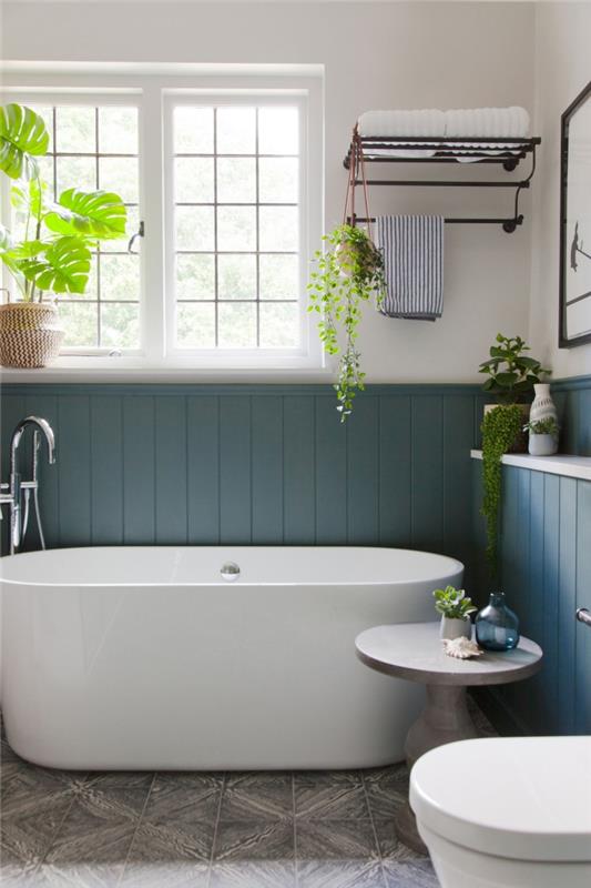 mažas vonios kambario išdėstymas su laisvai stovinčia vonia madinga tamsiai mėlyna sienų spalva