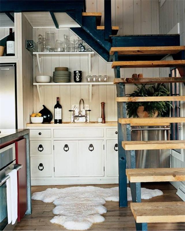 postavitev pod četrtletnim stopniščem z lesenimi dvižnimi vrati kuhinjsko omarico in brizganjem z beljenimi lesenimi deskami