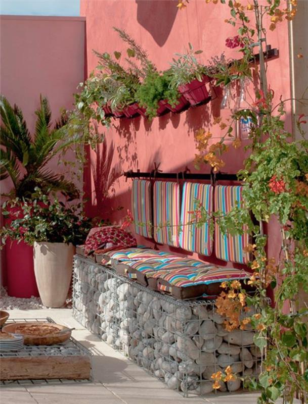 pastel çizgili taş tezgah için pembe renkli duvarlar ve minderler ile bahçe düzeni örneği