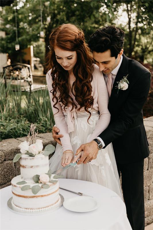 Įsimylėjusi pora, D diena, bohemiško prašmatnaus vestuvinio torto nuotrauka, papuošta rožėmis, romantiška vestuvių nuotrauka-pyrago puodelis