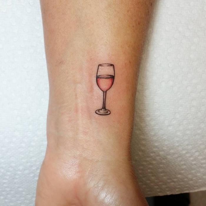 oblikovanje majhne tetovaže na zapestju s kozarcem rose vina, ideja za risanje s črnilom za žensko, ki obožuje vino
