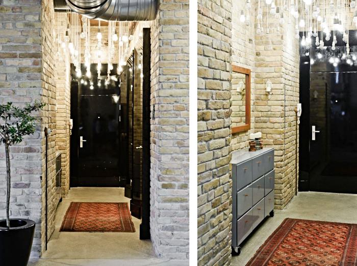 taş duvarlar ve görünür borularla koridor dekorasyonu, kablolarla modern aydınlatma ve farklı uzunluklarda elektrik ampulleri