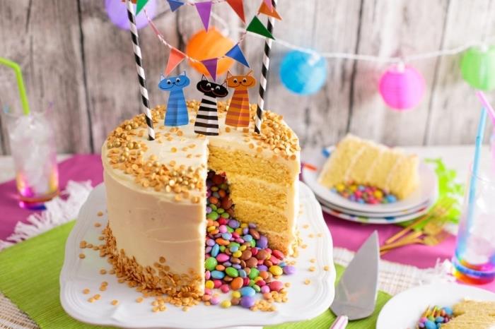 pametna torta z več plastmi vanilijeve biskvitne torte in glazure iz kremne omake, okrašena za otrokov rojstni dan s pasico in mačjimi tortami