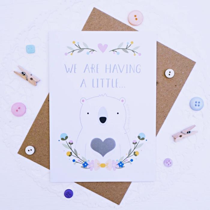 beyaz kağıttan şirin el yapımı bebek doğum duyuru kartı, sevimli çiçek tasarımları ve ortasında kalp olan küçük ayı
