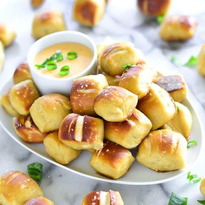 Aperitivo vegano con dei piccoli panini al formaggio ir contorno di salsa con erba cipollina