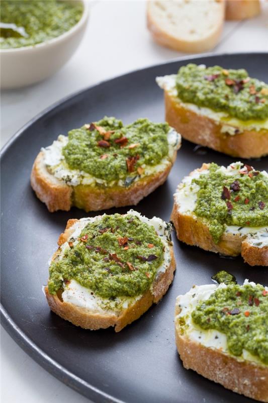 Finger food vegetariani e bruschette di pane con ricotta e pesto di basilico