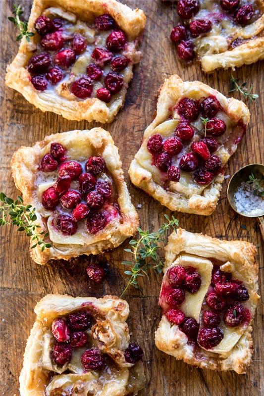 mini brie piškoti in zamrznjene brusnice, okrašene z vejicami timijana, enostavna predjed predjed iz listnatega testa