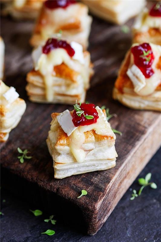 Stuzzichini salati vegan con dei piccoli panini di pasta sfoglia con formaggio sopra