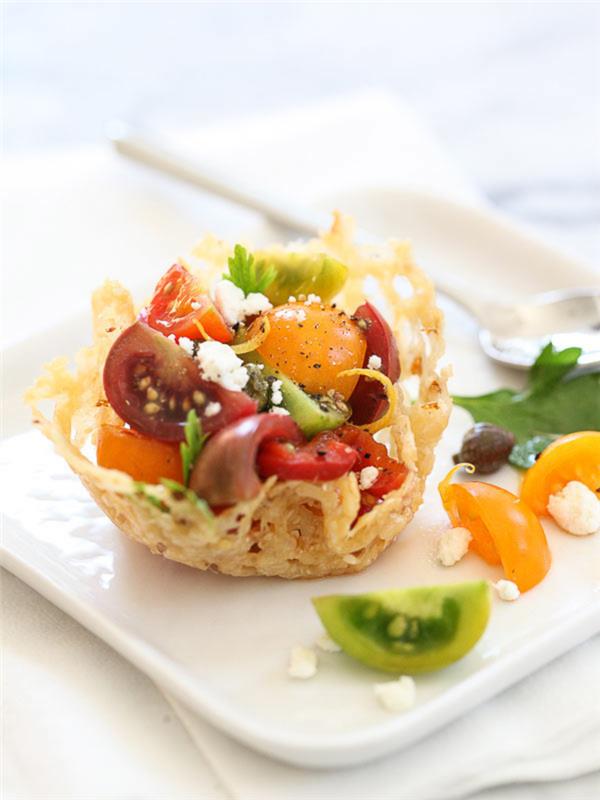 Antipasti veloci vegetariani con dei cestini di parmigiano grattugiato and pomodorini tagliati a metà