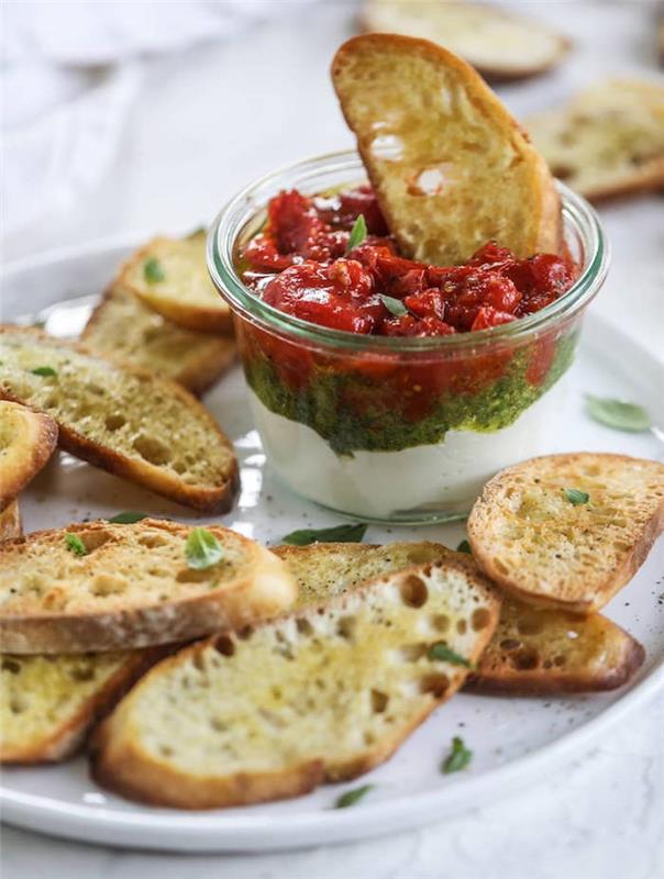 eleganten in enostaven aperitiv ricota pesto iz bazilike in paradižnikova marmelada, postrežen z domačimi brusketami