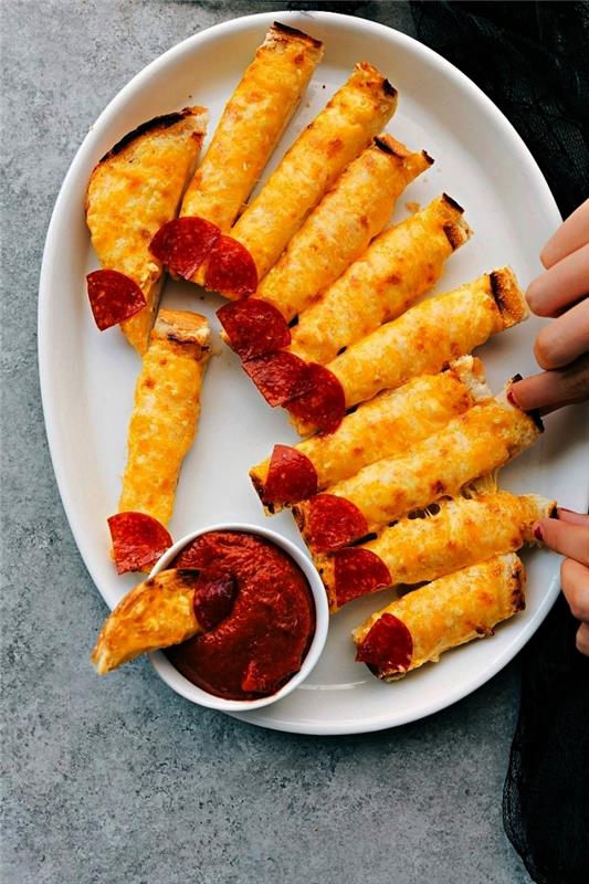 korkunç cadılar bayramı tarifi, peynirli ekmek çubukları ve domates sos ile servis edilen parmak salamı