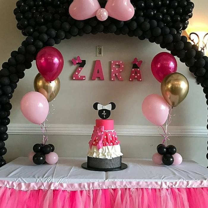 minnie mouse balionai deko, juodi balionai didelėje dekoratyvinėje arkoje, rožinis drugelis su dviem, minnie tortas, rožiniai balionai