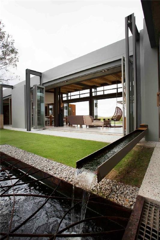 minimalistinė architektūra šiuolaikiškam namui su 1 aukšto ir žaliu vejos sodu