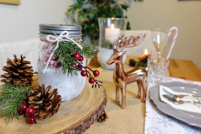 Kalėdų stalo dekoracijų pavyzdys, kurį lengva padaryti su nemokamais daiktais, medinis diskas, papuoštas kankorėžiais
