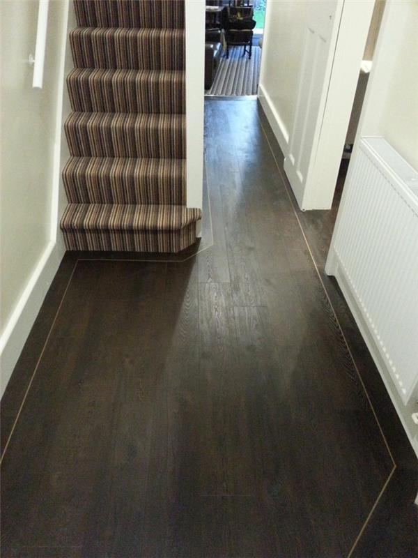 arredare-un-corridoio-pavimentazione-legno-colore-scuro-scale-tappeto-atnico-pareti-bianche