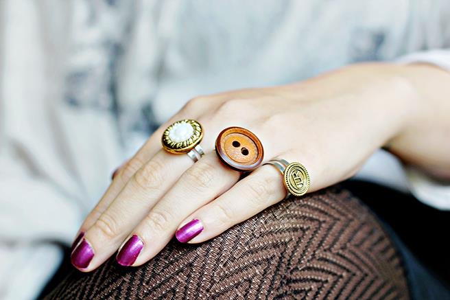 kadının eli, parlak mor oje, kolay sanatlar ve el sanatları, giysi düğmelerinden yapılmış üç yüzük