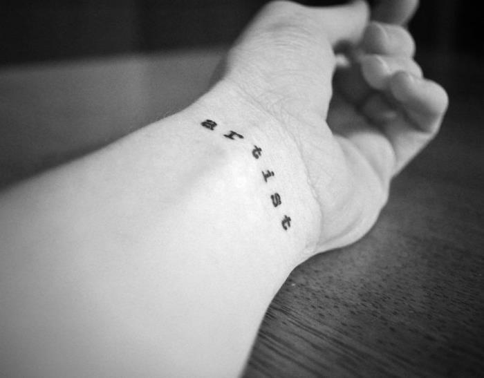 umetnik tetovaža zapestja, črno -bela fotografija, postavitev tetovaže, lesena miza
