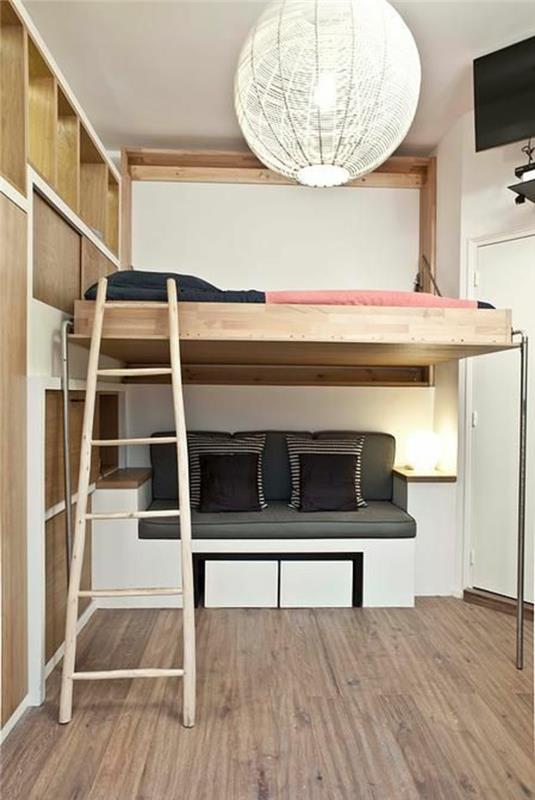 buto vidaus apdaila, dviaukštė lova ir maža poilsio zona žemiau, didelis šviestuvas baltais siūlais, taupe parketas, šviesios medienos kopėčios