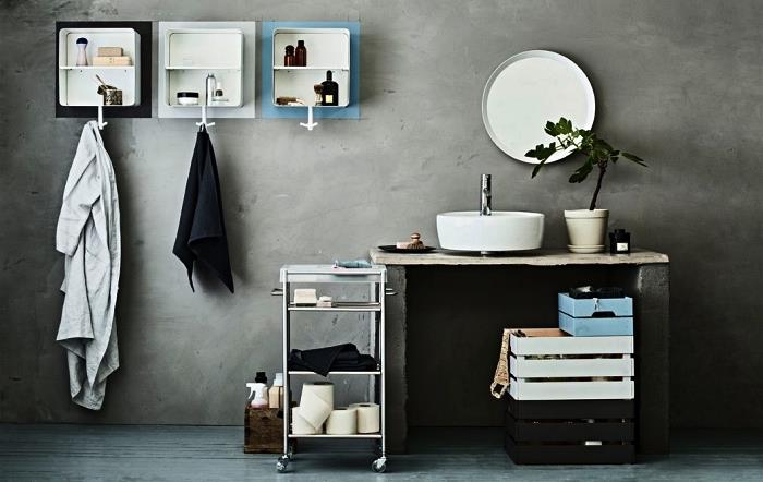 shramba za kopalnico z lastnimi rokami, zloženi leseni zaboji za shranjevanje, pobarvani v črno, belo in modro barvo, kopalnica iz cementa s cementnim umivalnikom