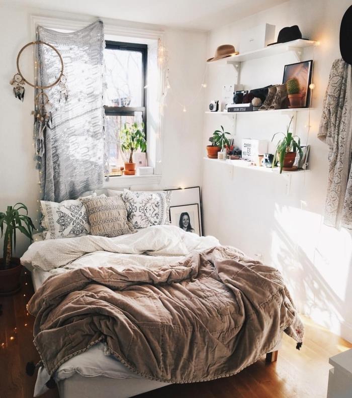 jaukią atmosferą mažame elegantiškame boho stiliaus kambaryje su medine lova ir sieninėmis lentynomis