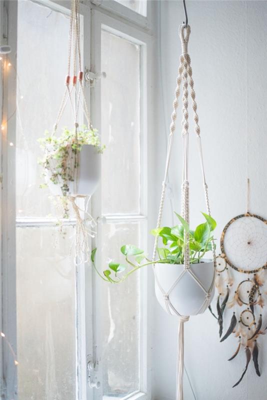 Beyaz duvarlı bohem yatak odası dekoru, kendin yap rüya yakalayıcı ve bir yatak odası için bitkiler olan pamuk ipten makrome bitkisi