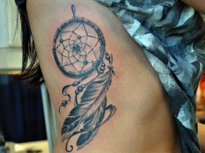 tetoviran lovilec sanj, ženska tetovaža na strani, perje, obeski, simbolično domače ameriško oblikovanje tetovaž