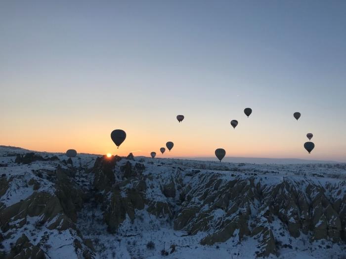 bilgisayar için kış manzarası fikri, gün batımının fotoğrafı ve karlı dağların üzerinde uçan gaz balonları