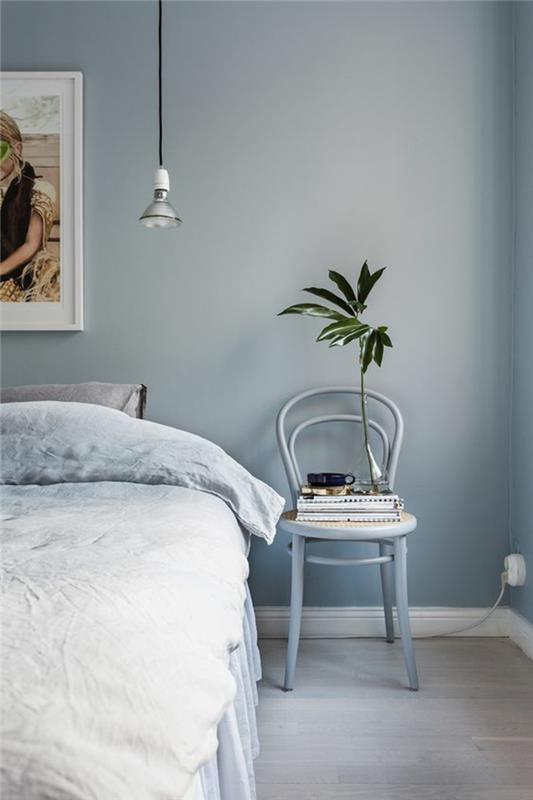 modra dekoracija spalnice za odrasle za pomirjujoče vzdušje velika slika nad posteljo in moderna žarnica, ki visi nad posteljo