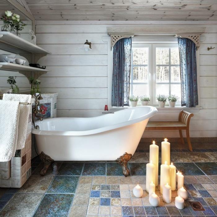 mavi ve beyaz banyo, yanan mumlar, mozaik zemin mavi perdeler, beyaz raflar, beyaz kalça banyosu, beyaz panelli duvarlar