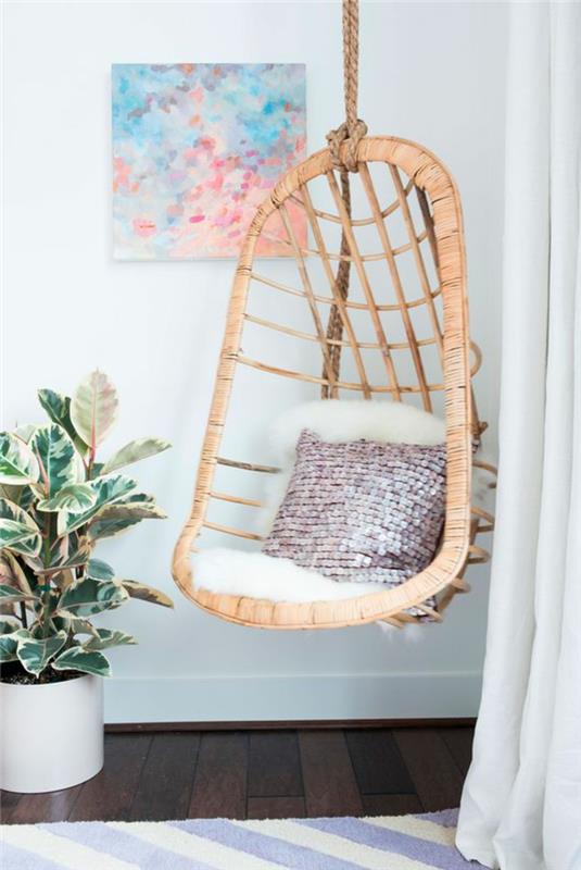 gugalnica za odrasle, viseči stol iz ratana, abstraktna slika in zelena rastlina
