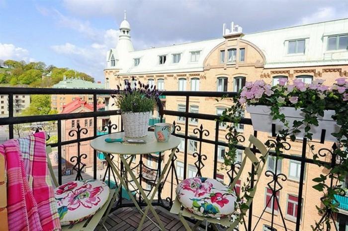 ideja za majhen cvetlični balkon s cvetličnimi škatlami in lonci, kovinskimi stoli, okrašenimi z blazinami s cvetličnimi vzorci