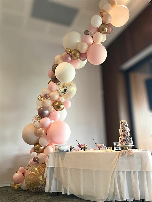 graži rožinių balionų ir metalinių spalvų mini balionų vestuvių arka, dideli balionai su konfeti, stalas