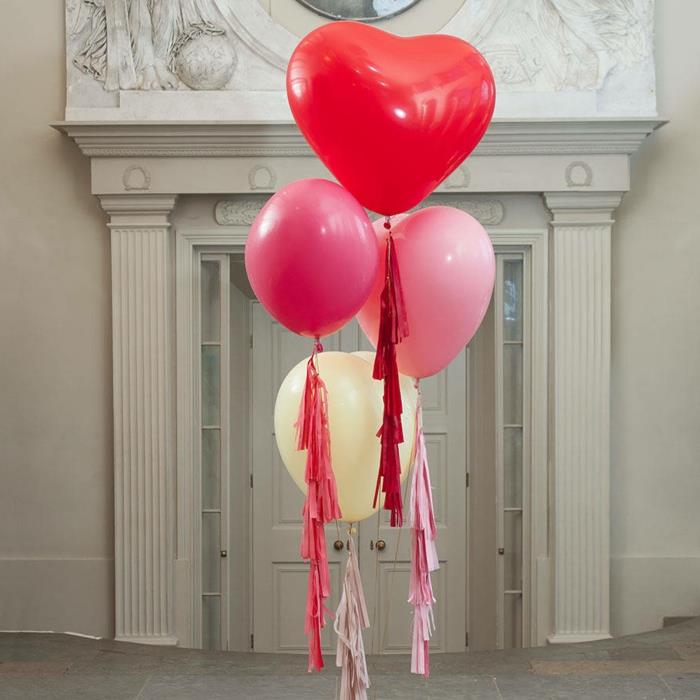 pririšti širdies formos balionai, plaukiojantys ore šalia didelių baltų durų, dekoratyviniai pakraščiai