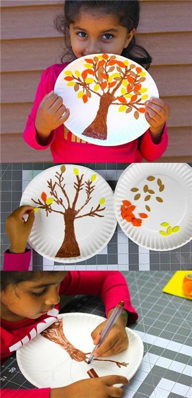 Una bambina che ha fatto un albero colorato su un piatto di carta