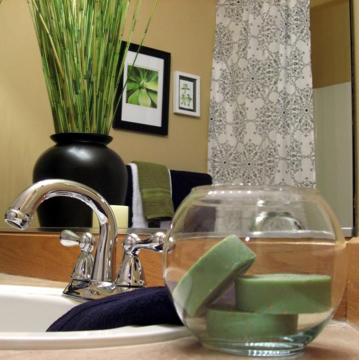 vonios kambarys, drėgmę sugeriantis augalas, juoda vaza su žaliais augalais, ovali balta kriauklė, juodos rėmo lentos ir baltos rėmo lentos
