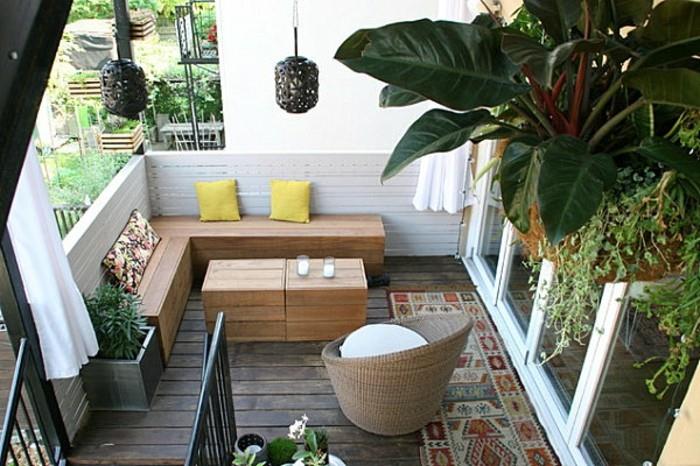 leseni kotni kavč z nizko leseno mizo, dotrajanim lesenim podom, ograjo v beljenih lesenih deskah, visečimi rastlinami, naslanjačem iz ratana
