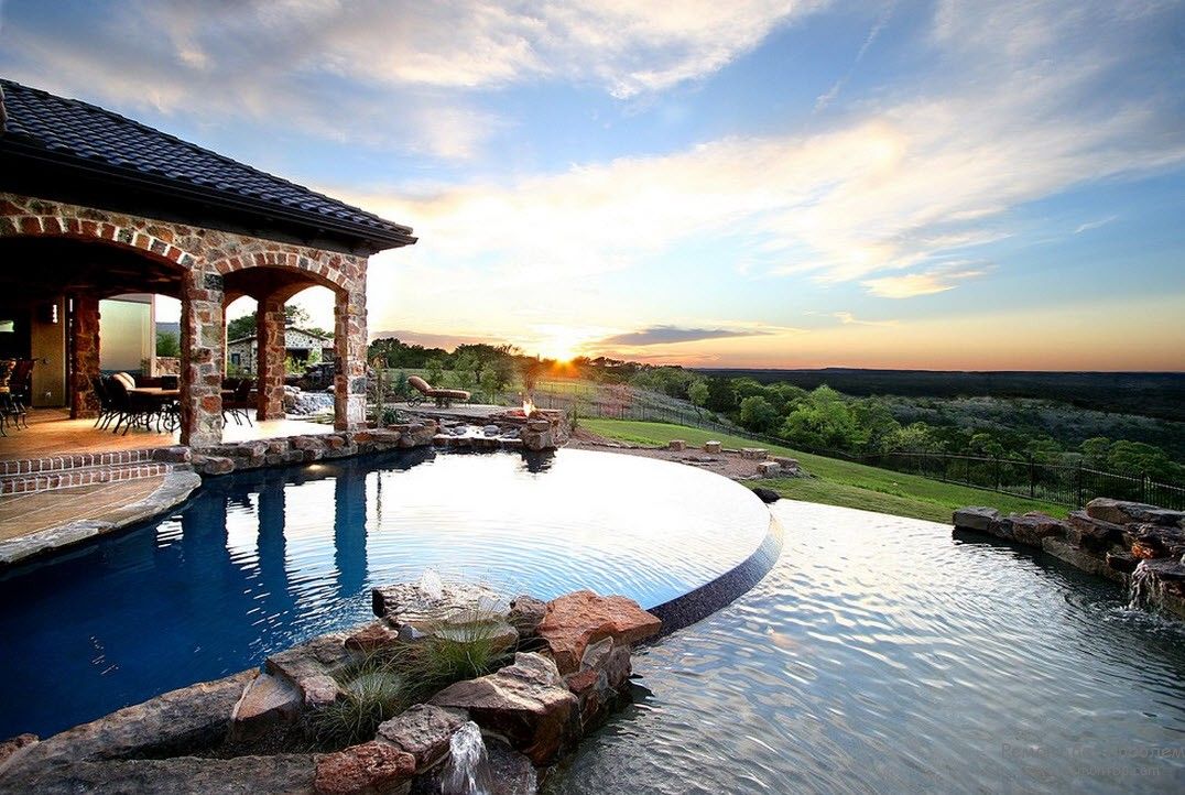 Elegantiškas baseino dizainas, esantis šalia namo, iš kurio atsiveria puikus vaizdas
