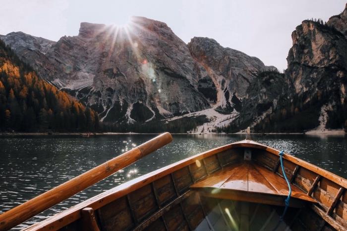 valties nuotrauka ežere kalnų širdyje, gražūs tapetai su saule virš uolų