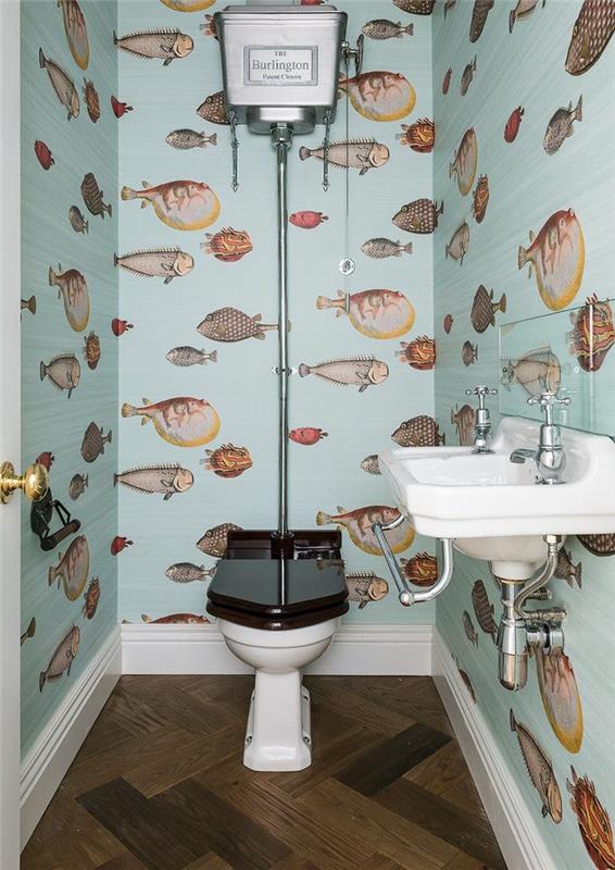 ideje za majhno kopalnico, ozko stranišče z bledo modro barvo, ozadje z vzorci rib, starinsko stranišče in umivalnik, temna lesena tla
