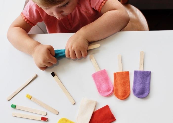 Bir kreşte Montessori pedagojisi, renkli keçe kaplama ile eşleştirmek için renkli uçlu dondurma çubukları