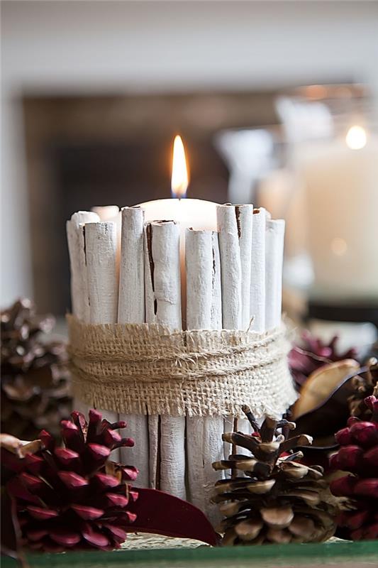 Kalėdinis dekoratyvinis objektas pasigaminti patiems, pasidaryk pats dekoravimas su dažytais kankorėžiais ir cinamono lazdelėmis papuošta žvakė