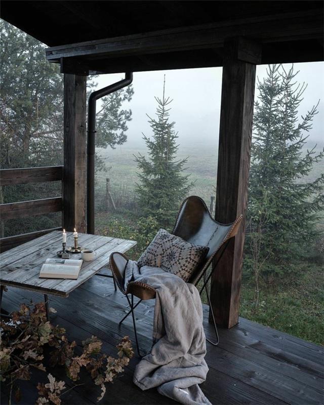 Namelis su balkonu miške, gražūs kokono tapetai, jauki stalo ir kėdės dekoravimo nuotrauka