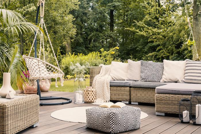 Udobno oblikovalsko vrtno pohištvo, kotni kavč iz ratana, prijetne blazine, gugalnice na vrtu, okrogla preproga