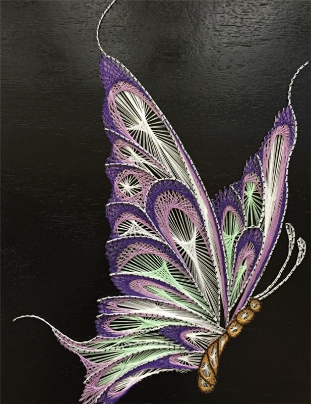 kūrybiniai pomėgiai su gražių kūrinių iš verpalų kūrimo technika, 3D drugelio modelis ant juodos medinės lentos